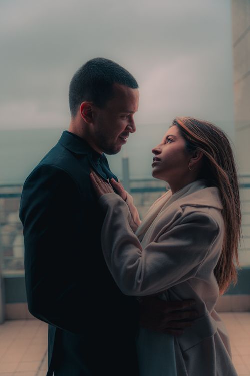 Free A couple embraces tenderly on a balcony during twilight, showcasing love and connection. Stock Photo