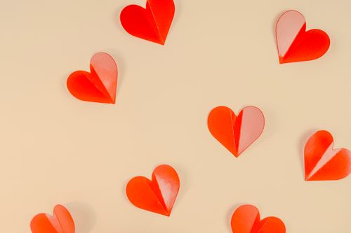 Free Artistic arrangement of red paper hearts creates a romantic mood. Stock Photo