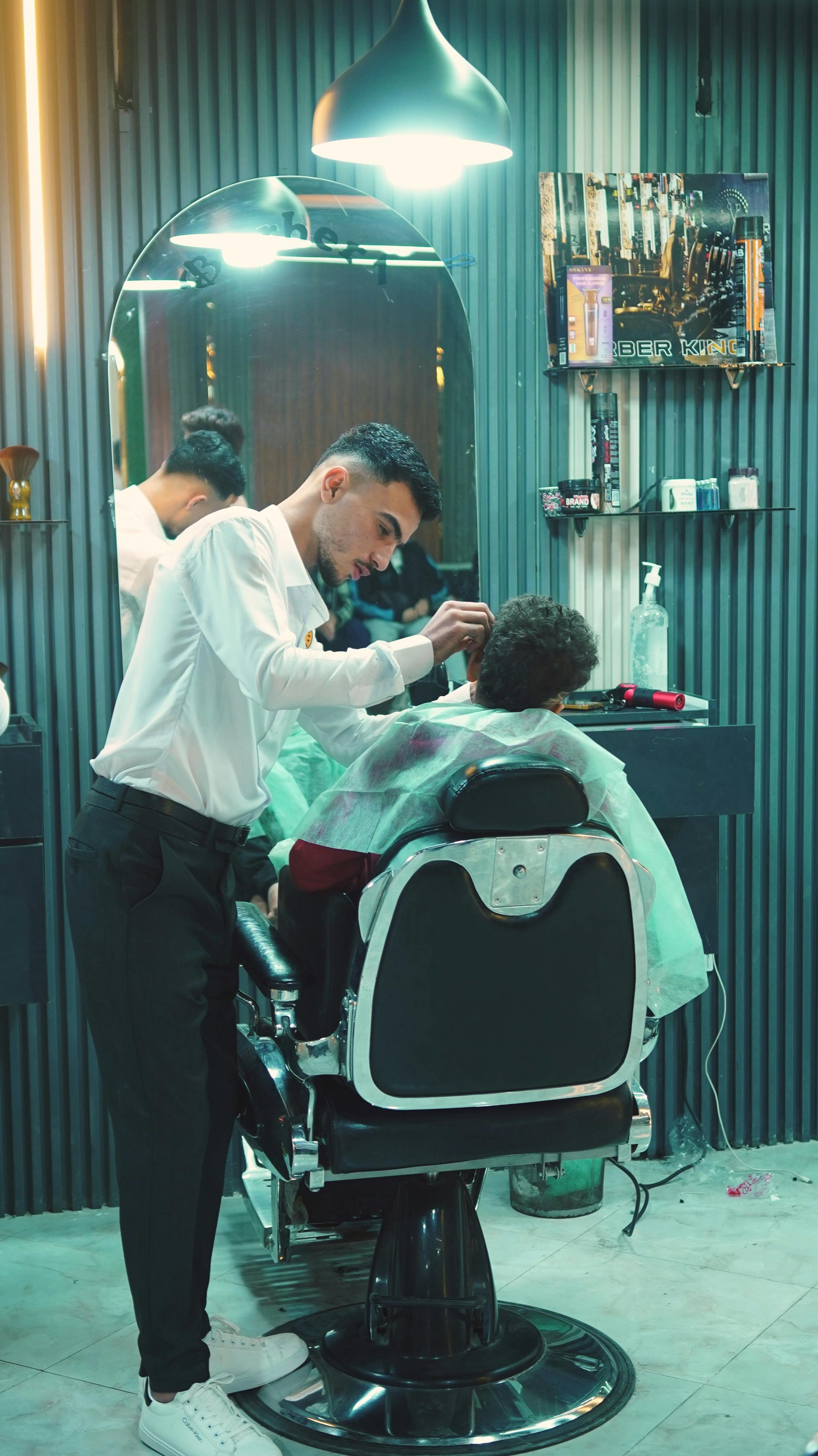 A barber in Egypt expertly styling a customer's hair in a modern barbershop.