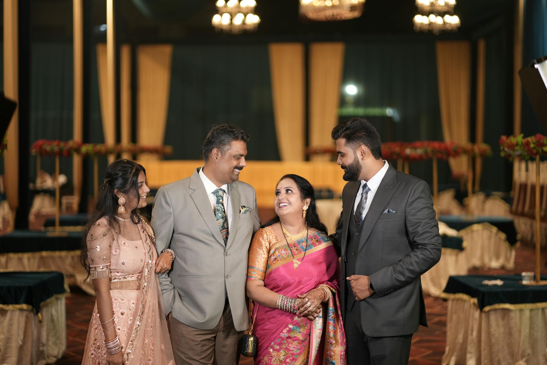 Family dressed in traditional and formal attire during an indoor celebration event.