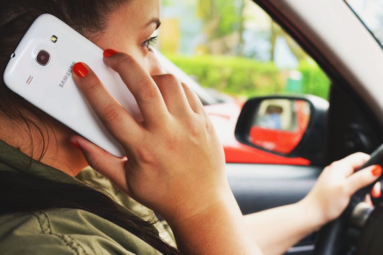 Woman Driving Car While Calling On Smartphone