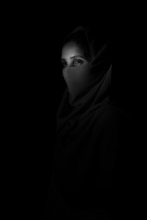 Free A captivating monochrome portrait of a woman in a headscarf, showcasing low light photography techniques. Stock Photo