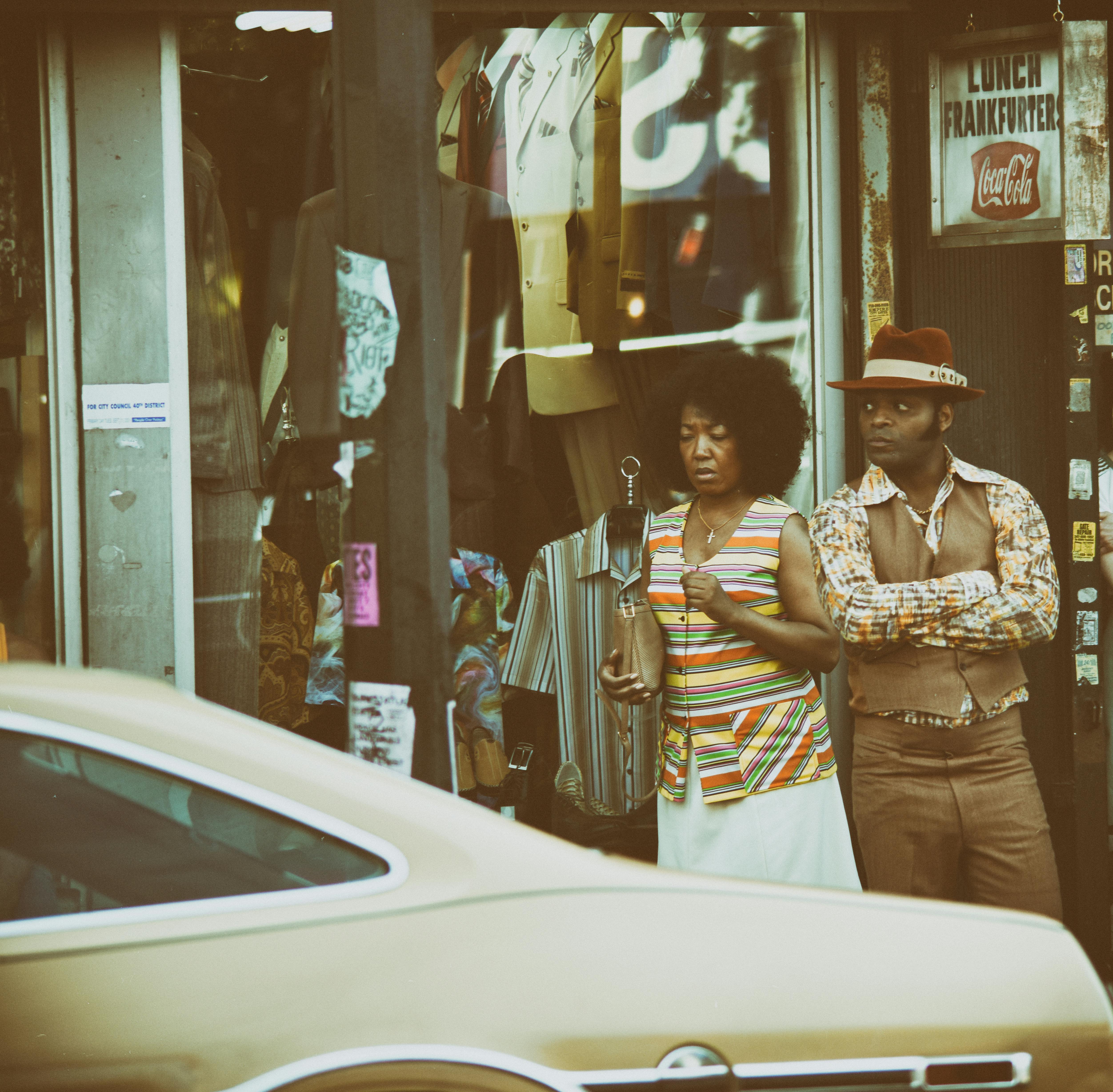 man and woman standing near beige vehicle