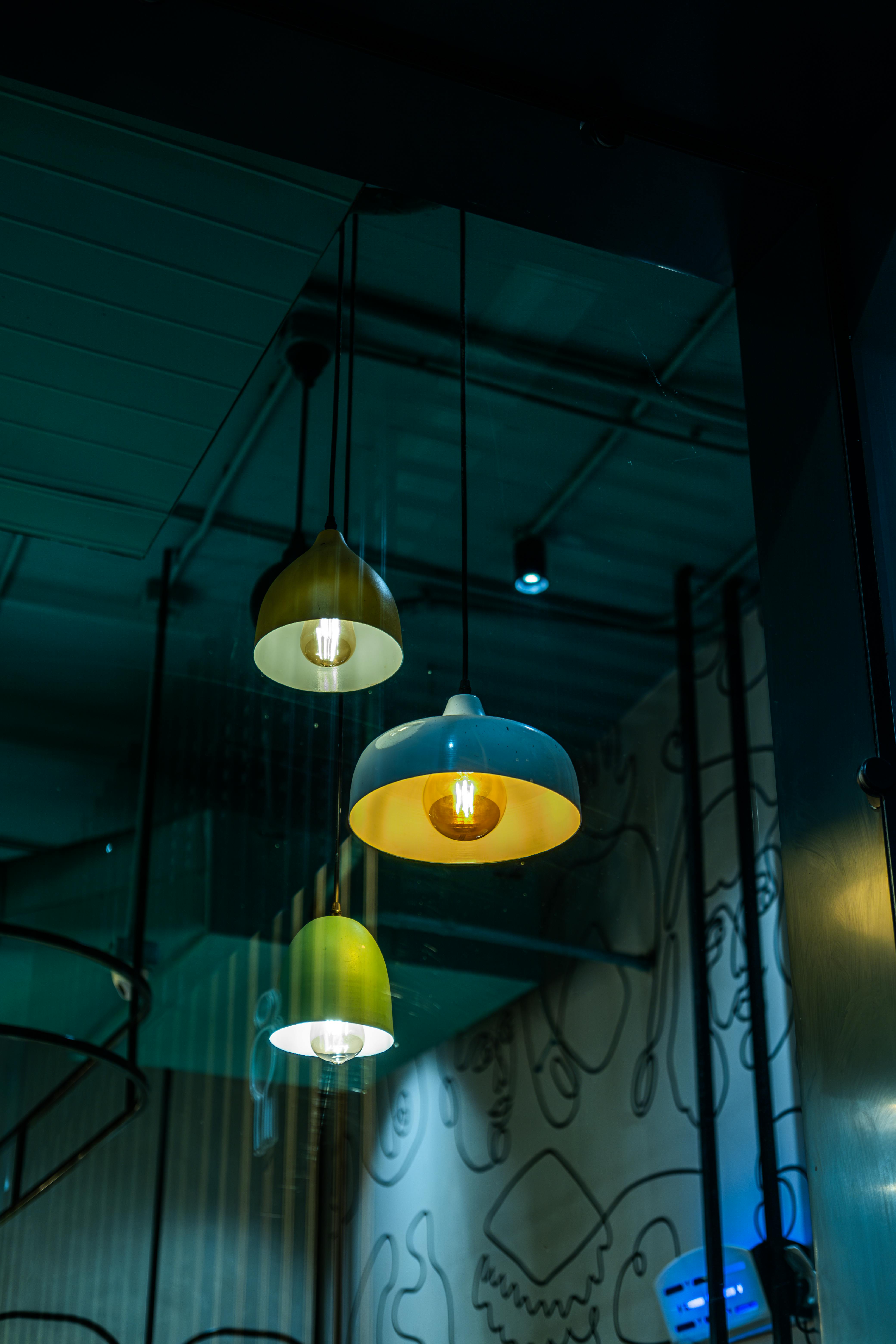 A trio of stylish pendant lights hanging indoors, casting a warm glow in a modern setting.