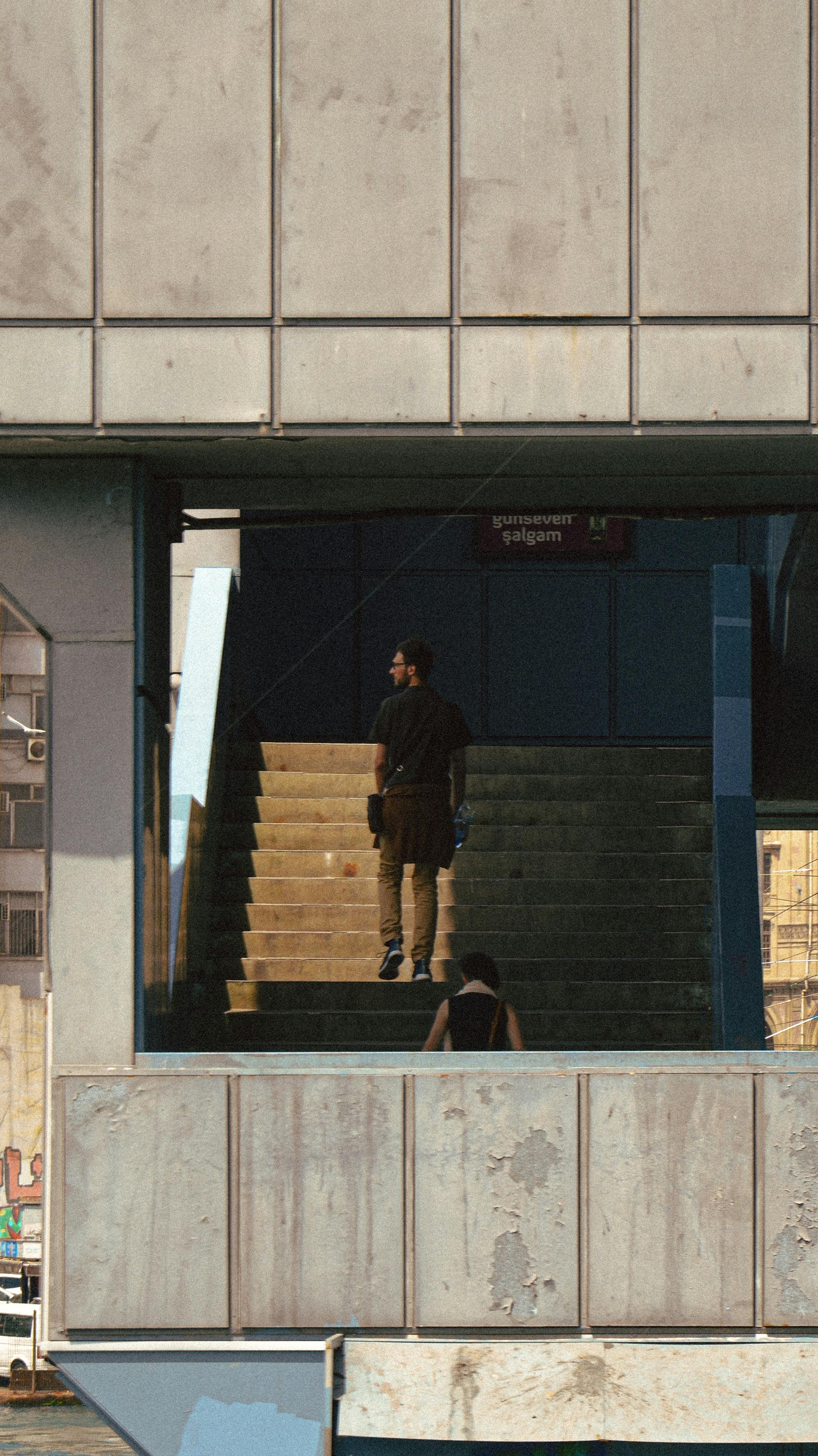 Ücretsiz Uzaktan çekilmiş bir fotoğrafta, kentsel bir ortamda merdiven üzerinde yalnız bir kişi duruyor. Stok Fotoğraflar