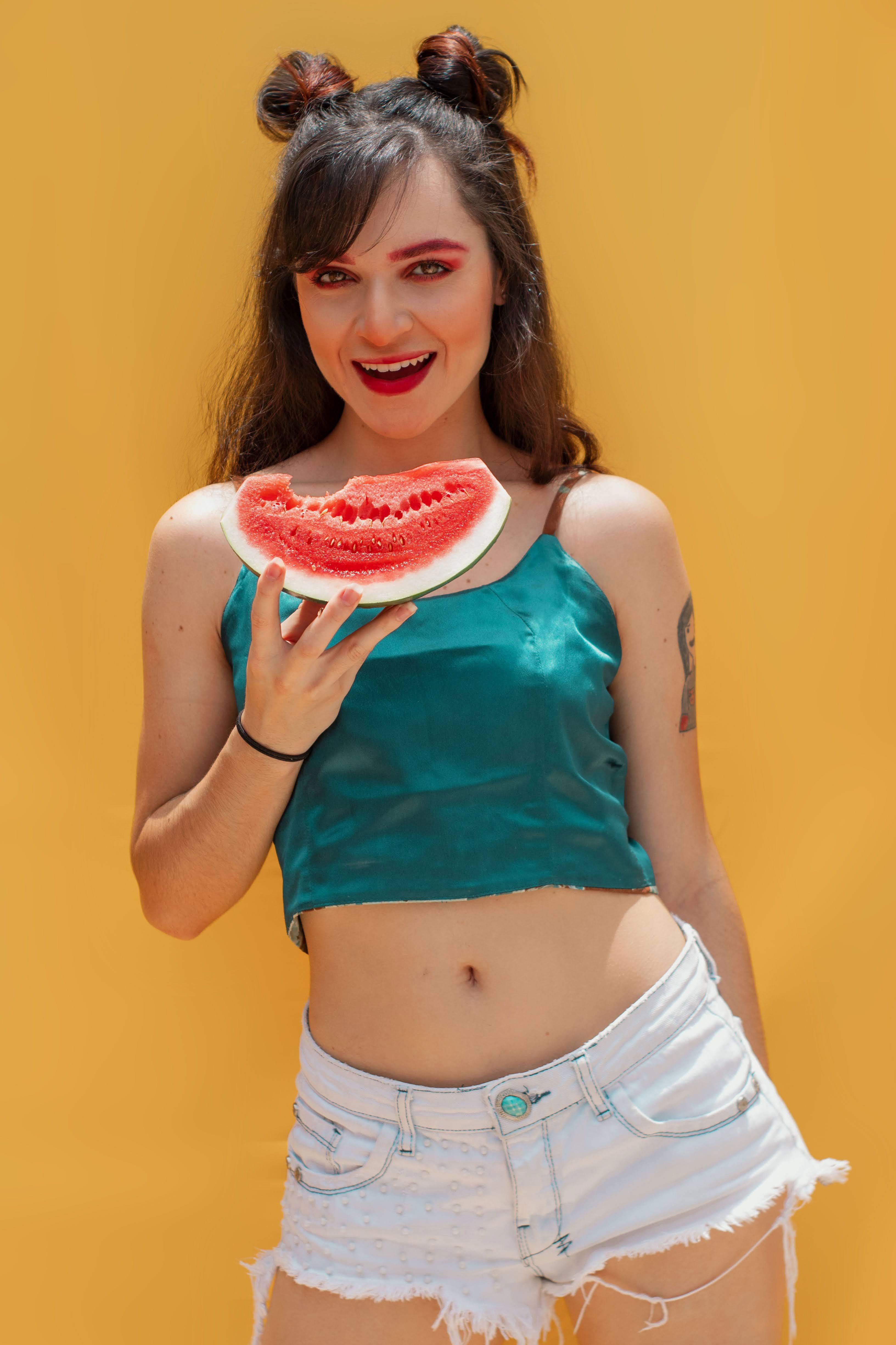 Young woman enjoying a fresh slice of watermelon on a sunny day in São Paulo.