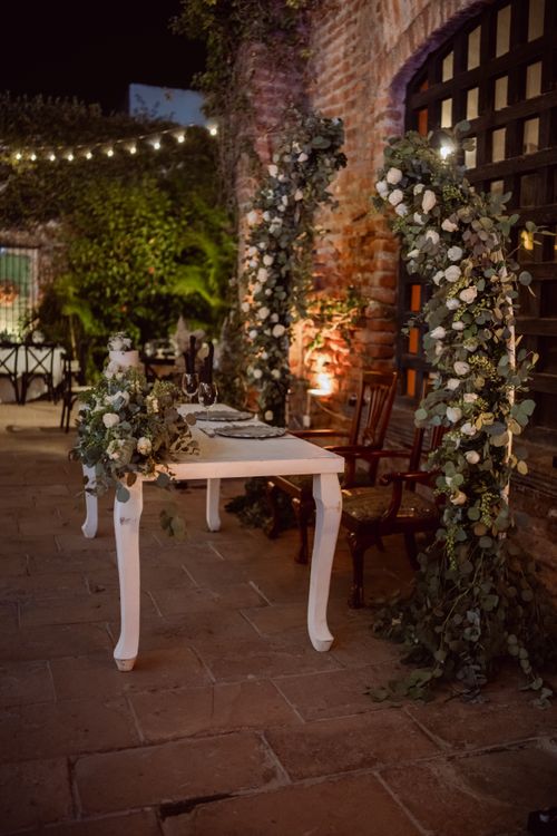 Free Beautifully decorated wedding table with floral arch and night lights in an outdoor setting. Stock Photo