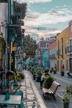 Charming street in Puebla, Mexico with vibrant buildings and string lights, capturing a lively evening ambiance.