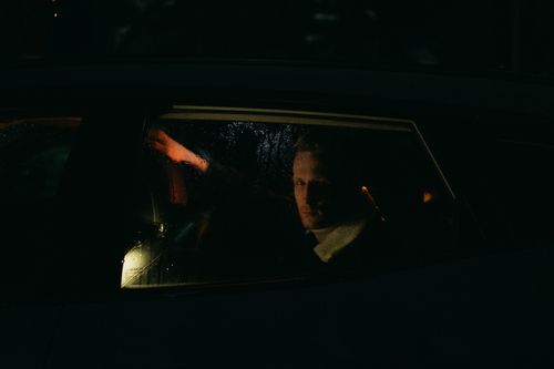 Free A mysterious man gazes through a rainy car window in low light. Stock Photo