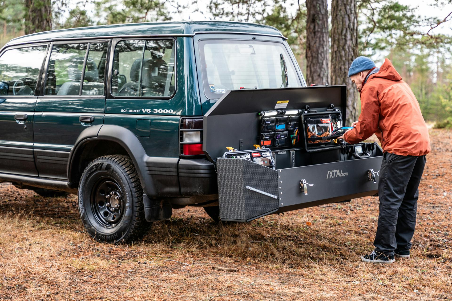 A rugged vehicle with a versatile storage solution in a forest setting, ideal for outdoor adventures.