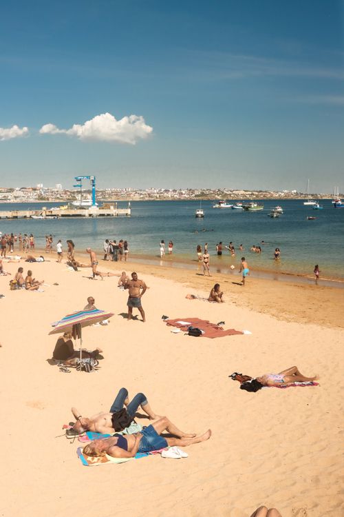 Free Relaxing beach scene in Porto, Portugal, with people enjoying sun and sea. Stock Photo