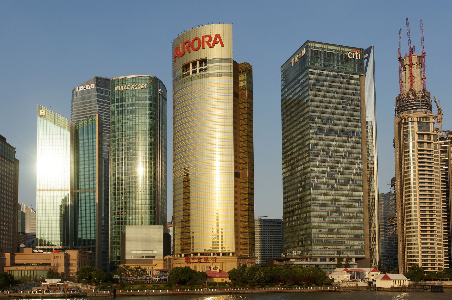 A stunning view of Shanghai's iconic skyscrapers reflecting sunlight during sunset.