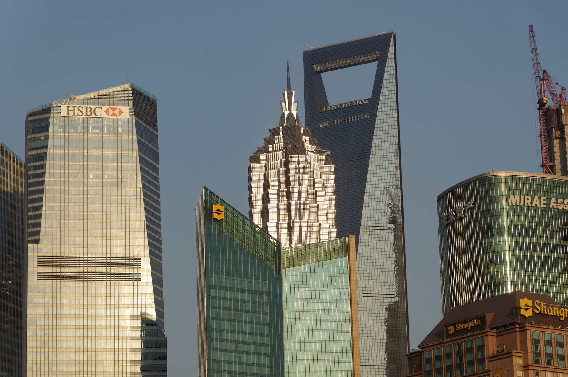 Iconic skyscrapers towering in Pudong, Shanghai under a clear blue sky.