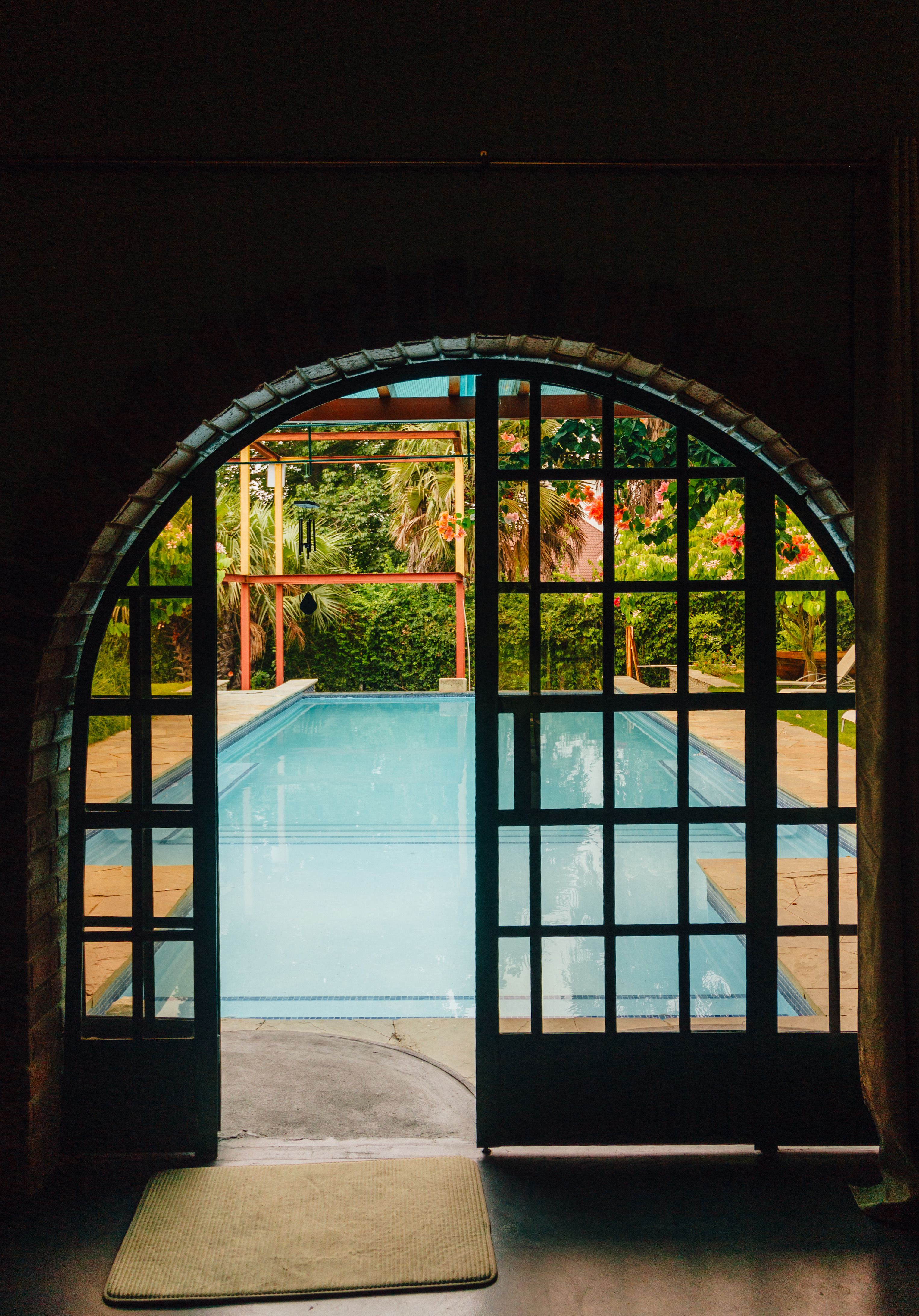 Inviting Pool View through Arched Glass Doors · Free Stock Photo