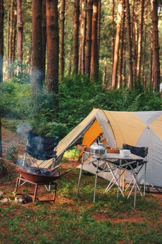 A serene camping scene in a forest with a tent and bonfire. Perfect for outdoor adventure enthusiasts. - Fotografer Sidoarjo