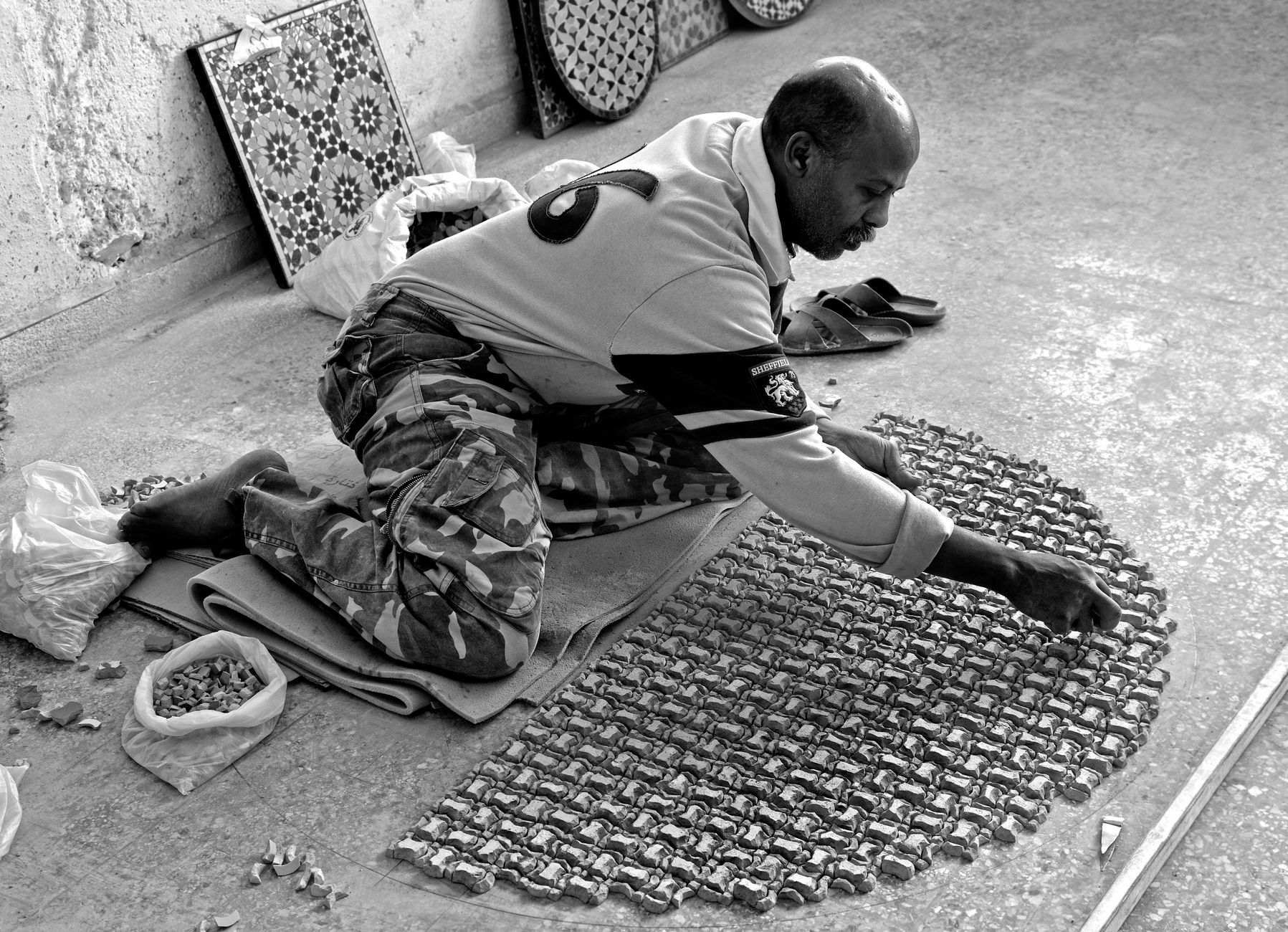 Skilled artisan creating intricate mosaic art in Fès, Morocco.