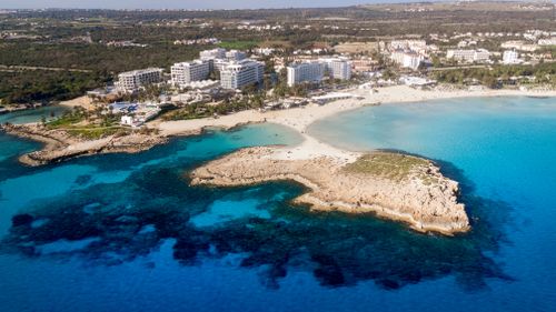 Free Aerial view of Ayia Napa's pristine coast with turquoise waters and resort buildings. Stock Photo