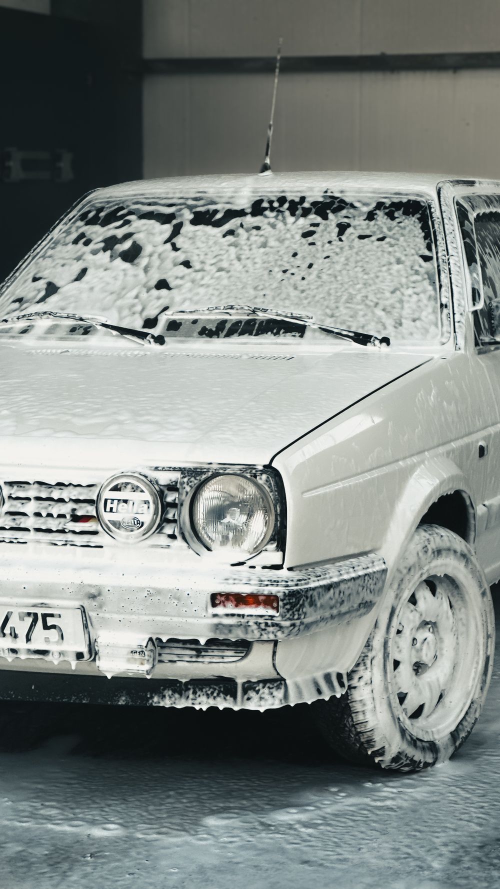 Car covered in soap foam during a hand wash