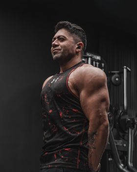Adult man lifting weights in a gym, showcasing strength and fitness.