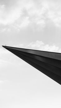 A minimalist black and white photo of sharp architectural lines against the sky.
