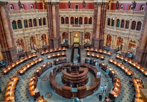 Aerial view of the historic Library of Congress reading room with people and beautiful architecture.