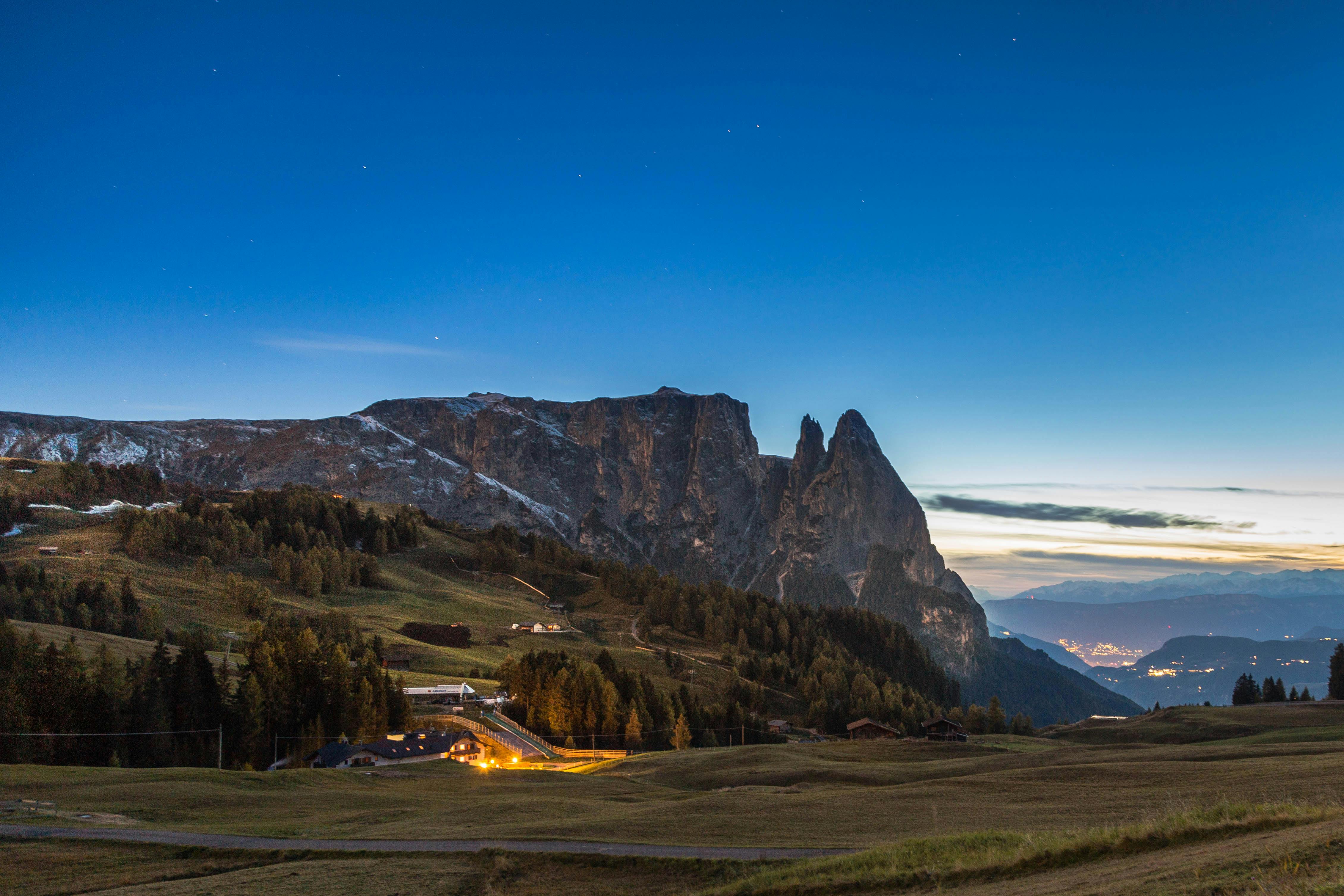 Stunning twilight landscape of mountain peaks and meadows in the Alps, showcasing nature