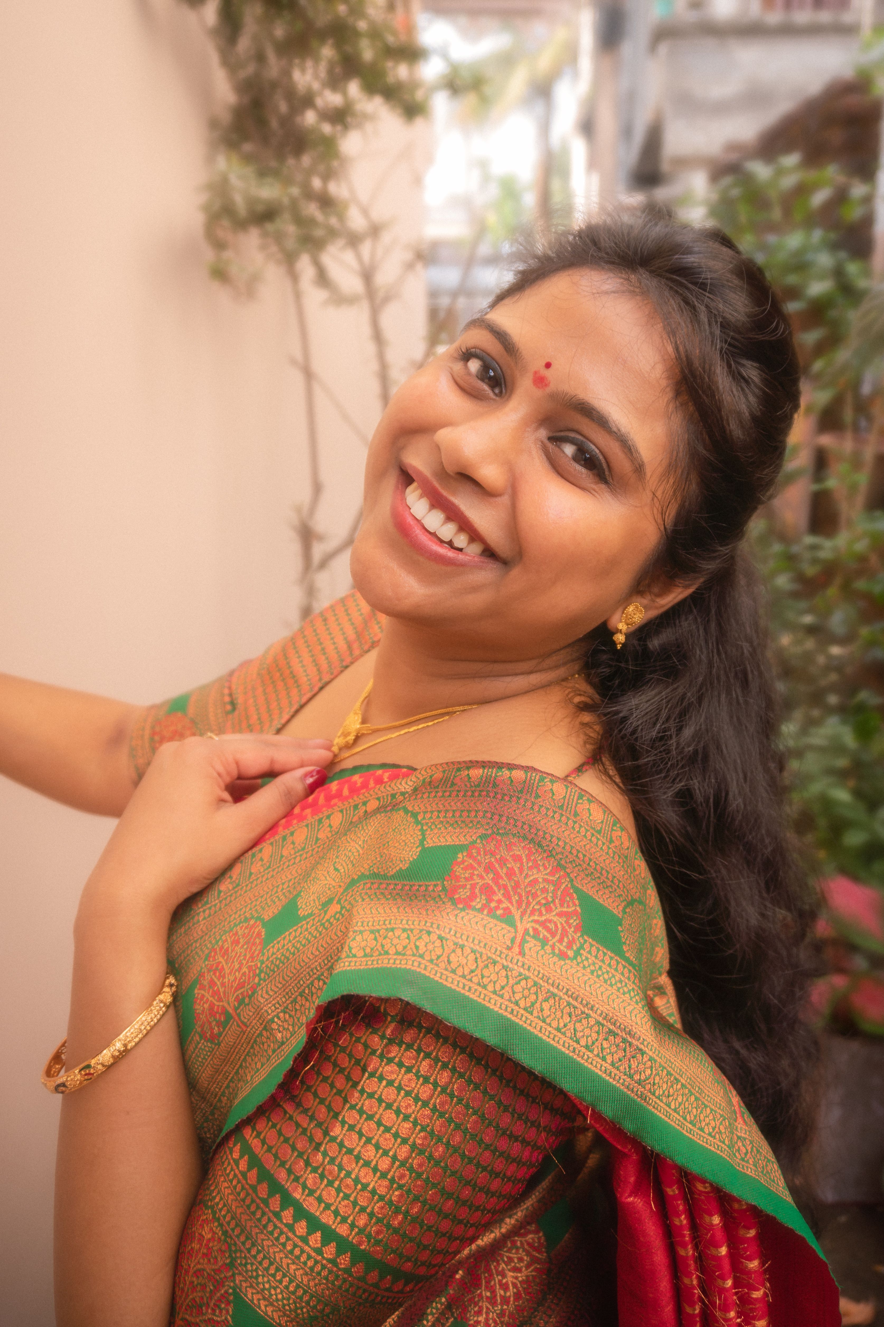 Radiant woman in a vibrant saree exuding cultural elegance.