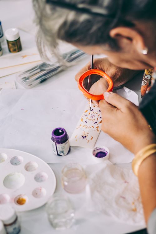 Free Artist hand-painting artwork with vibrant watercolors for a creative craft project. Stock Photo