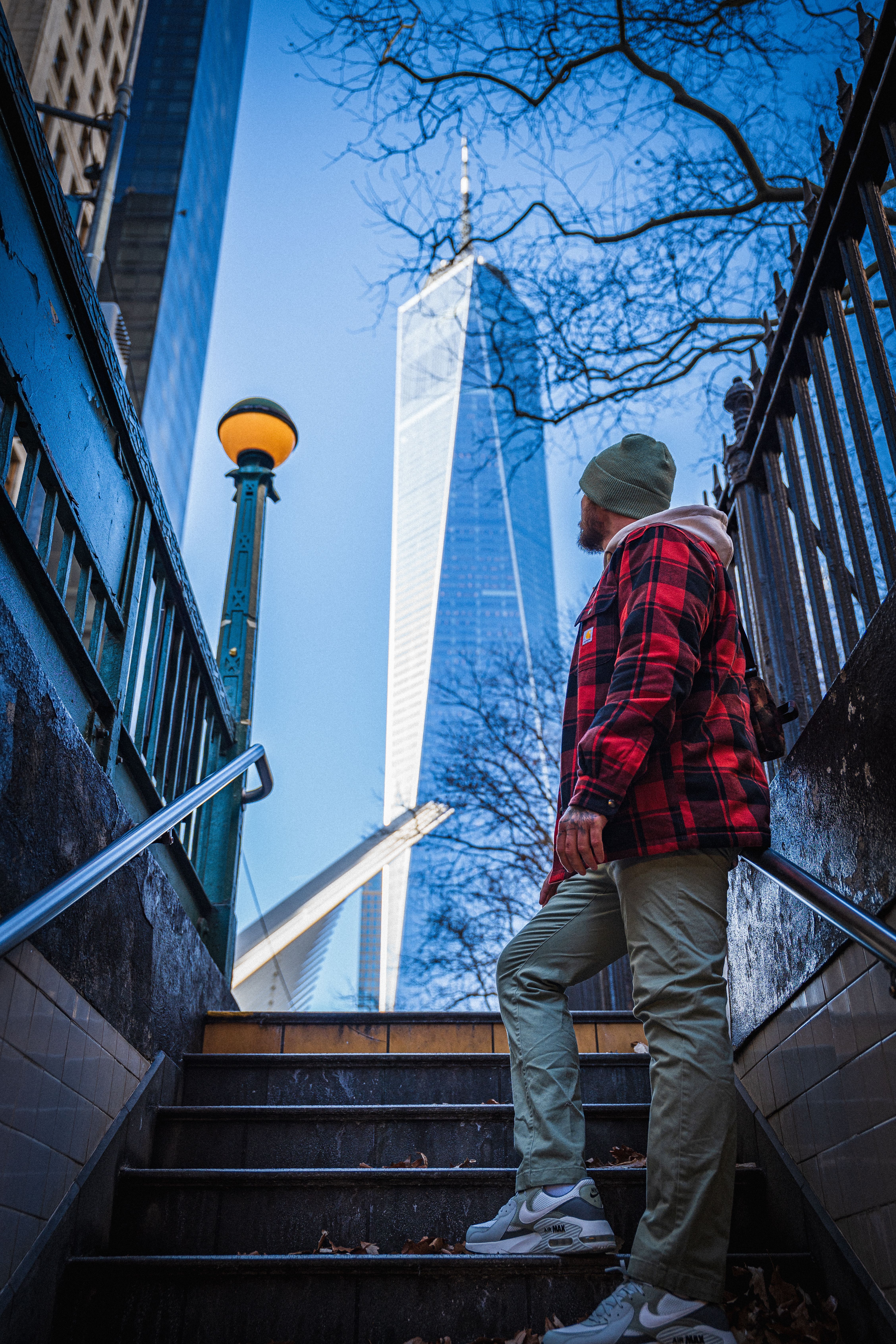 A man in plaid explores the vibrant surroundings of One World Trade Center in New York.