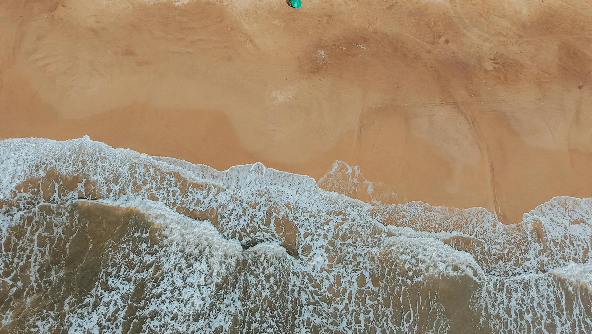 Discover the serene beauty of Imbé's golden sandy beach with gentle waves and natural tranquility.