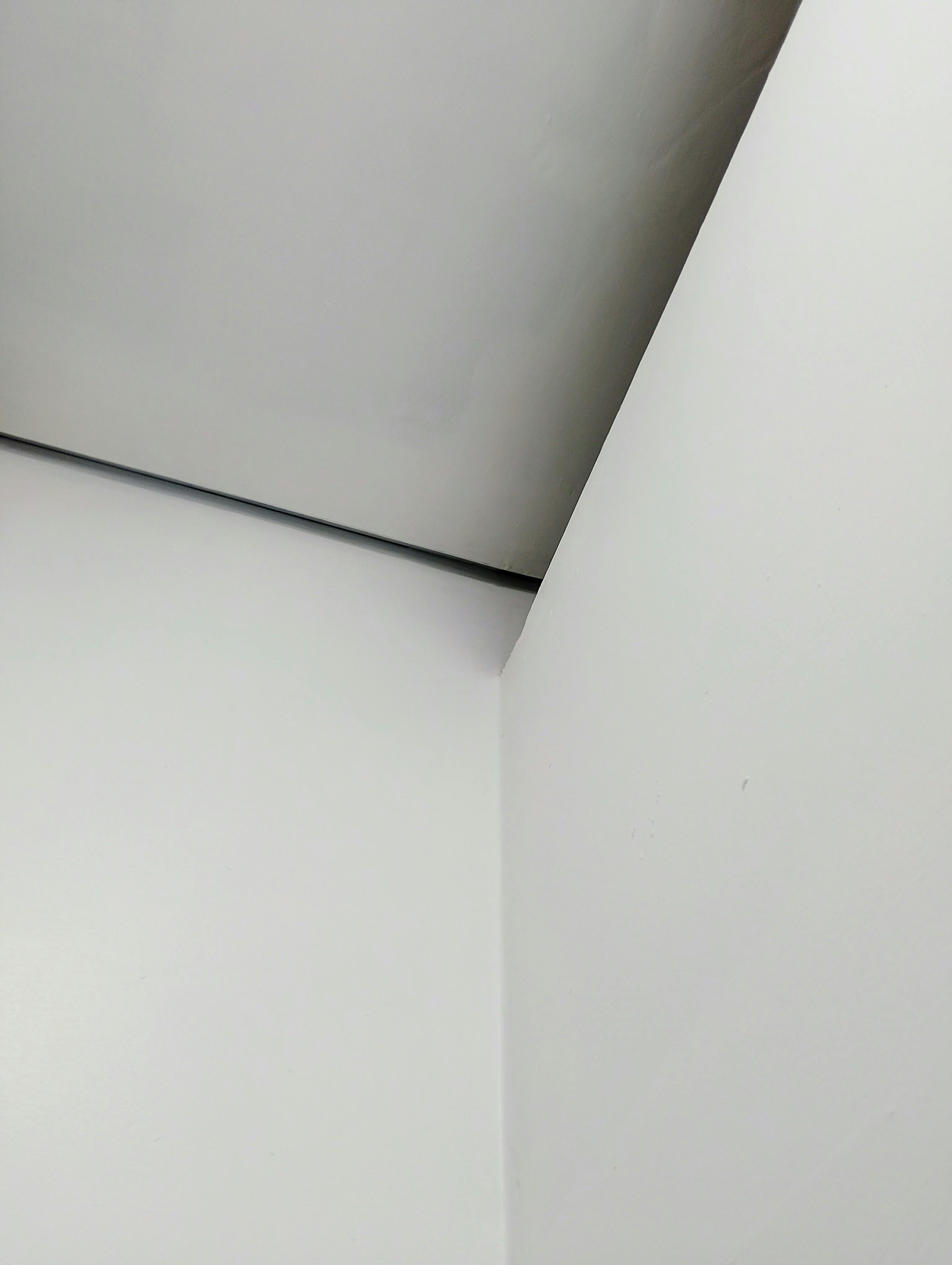 Free A minimalist geometric photo of a white corner with subtle shadows playing across the surfaces. Stock Photo