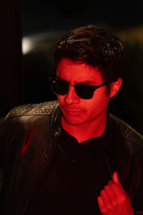 Free Stylish man in leather jacket and sunglasses under red lighting outdoors. Stock Photo