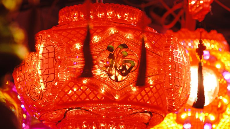 Colorful Chinese lanterns glowing brightly in night festival decor.