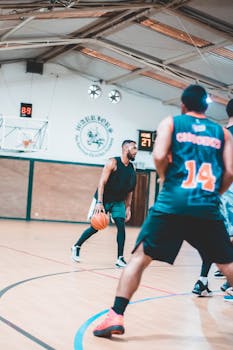 Players engaged in a dynamic indoor basketball game showcasing skill and teamwork.