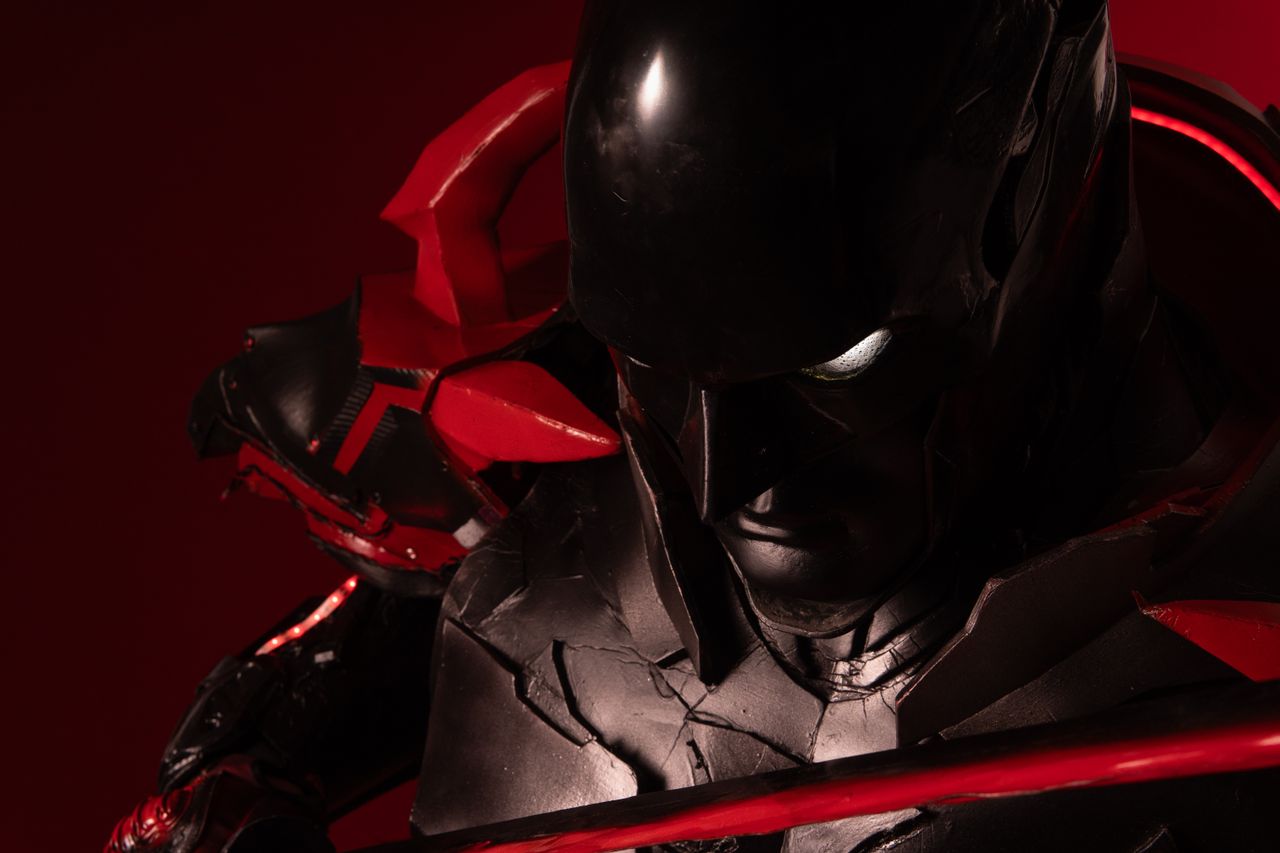close up of a character in an intricate red and black cosplay costume