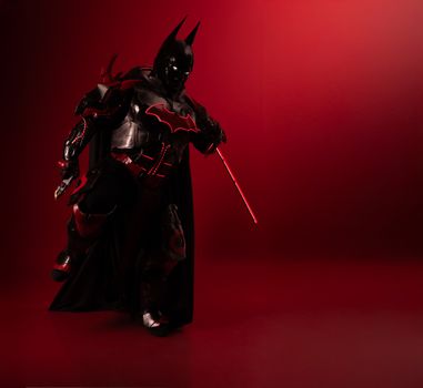 Detailed Batman cosplay in red-black theme, captured with dramatic lighting and mood.