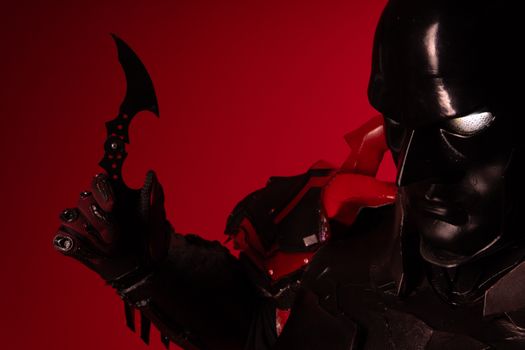 Striking cosplay portrait featuring a dark character with a red background.