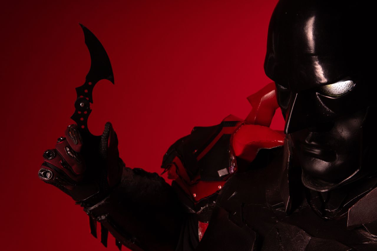 striking cosplay portrait featuring a dark character with a red backgr