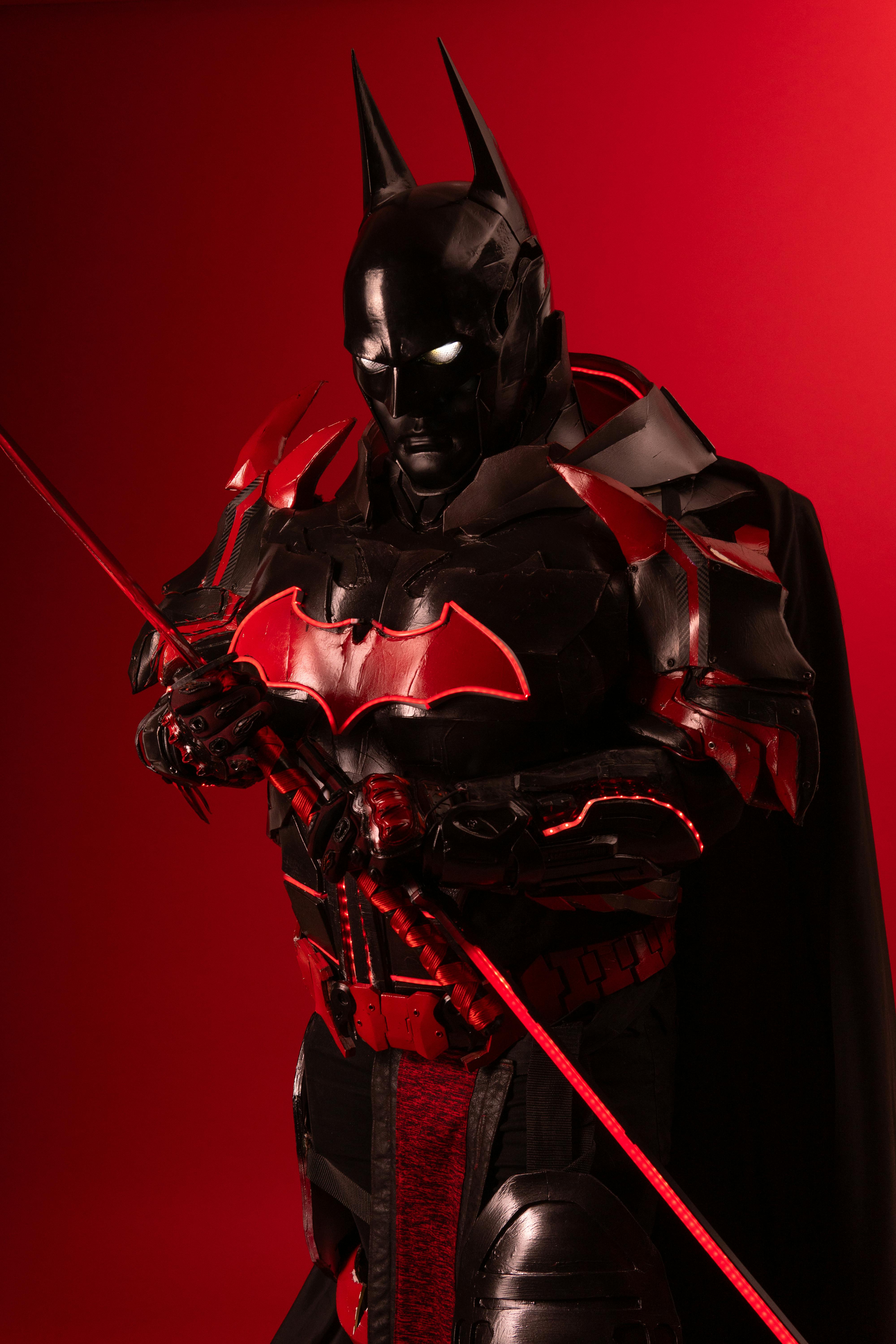 Ücretsiz Çarpıcı kırmızı bir arka plan önünde parlayan gözlere sahip, canlı Batman esintili samuray cosplay'i. Stok Fotoğraflar