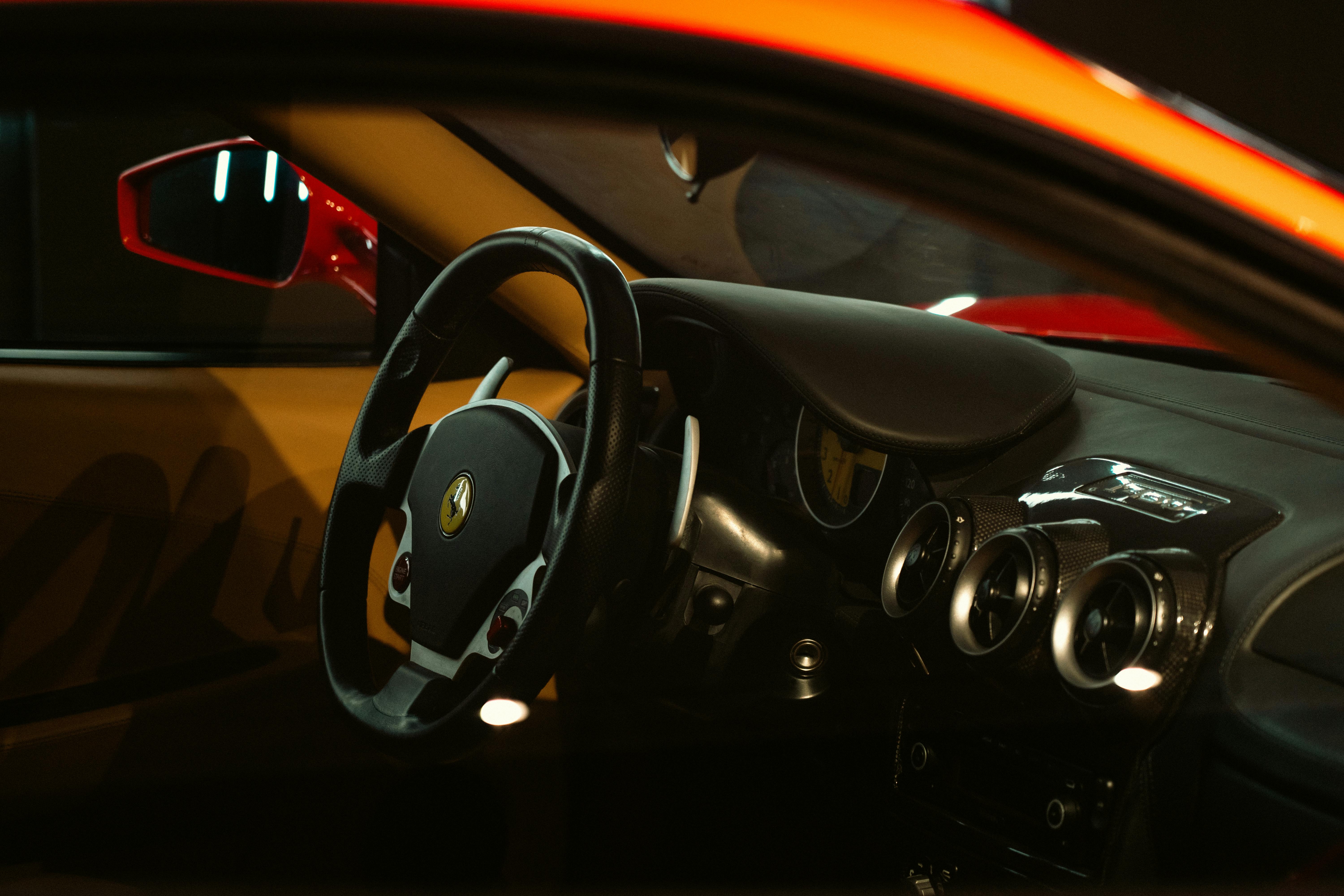 Close-up of a luxurious sports car interior showcasing the steering wheel, dashboard, and sleek design.