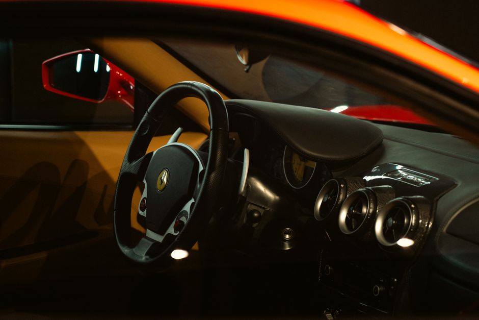 Close-up of a luxurious sports car interior showcasing the steering wheel, dashboard, and sleek design.