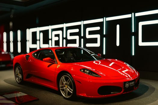 Vibrant red sports car displayed in a modern and stylish showroom with classic design.
