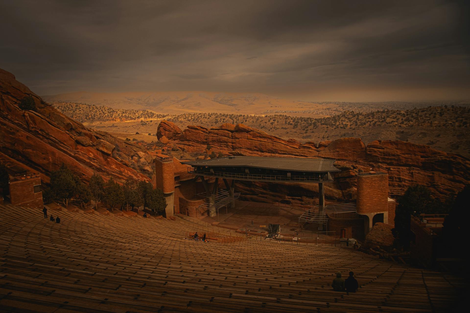 Red Rocks Amphitheatre amidst dramatic reddish rocks under an evening sky.