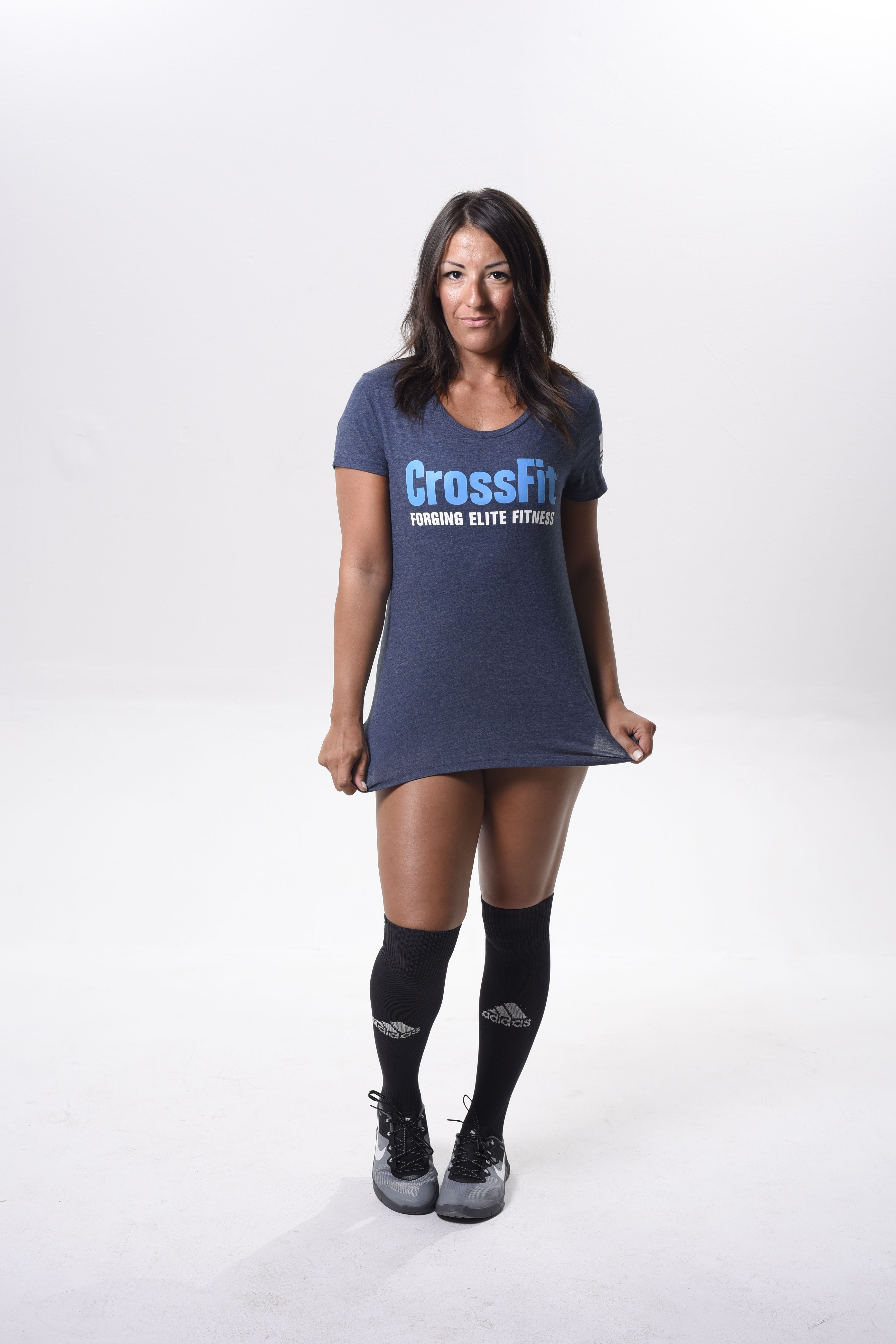 Confident woman in CrossFit attire standing against a white background.