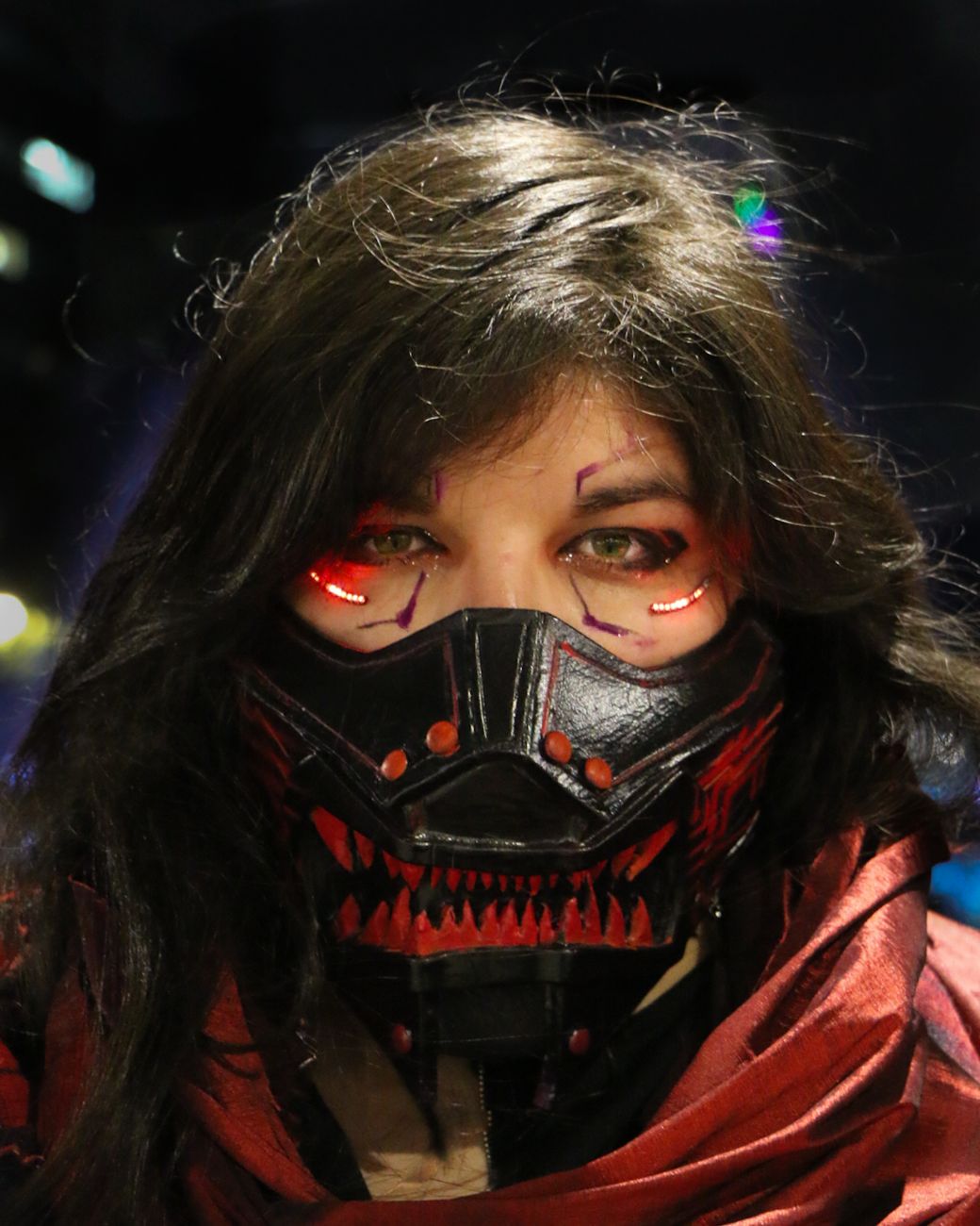 Close-up of a person in a futuristic cosplay outfit with LED illuminated mask.