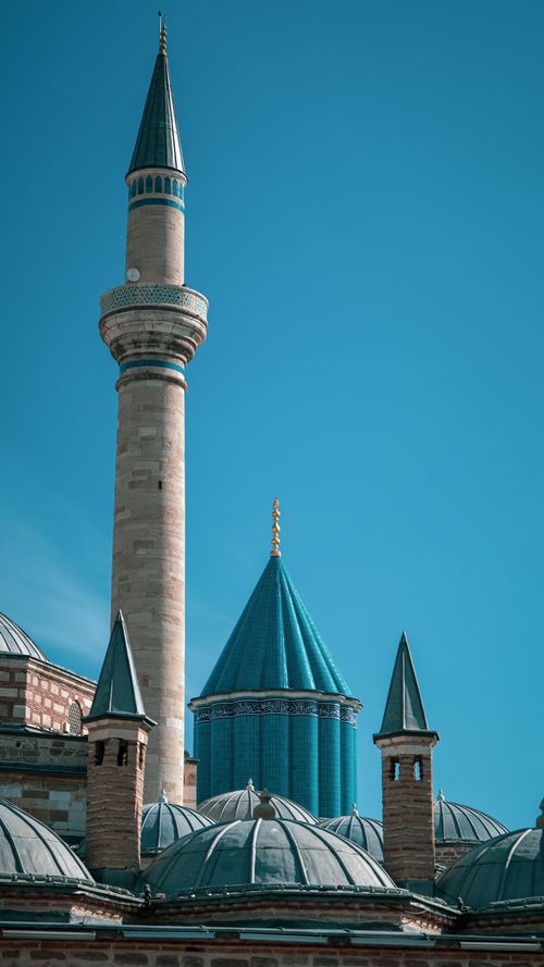 Free Elegant mosque minaret with turquoise domes under a clear sky, showcasing Islamic architecture. Stock Photo