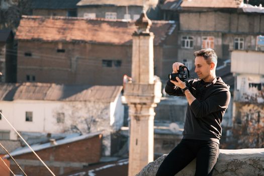A photographer takes pictures in a historic urban area, capturing the city's essence.