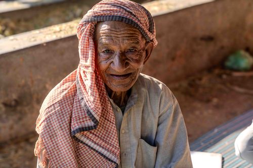 Free Portrait of a senior man wearing a traditional headscarf, smiling warmly outdoors. Stock Photo