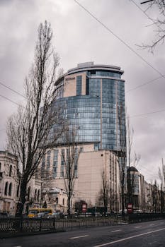 Urban scene with the Hilton Hotel in Kyiv, showcasing modern architecture on a cloudy day.