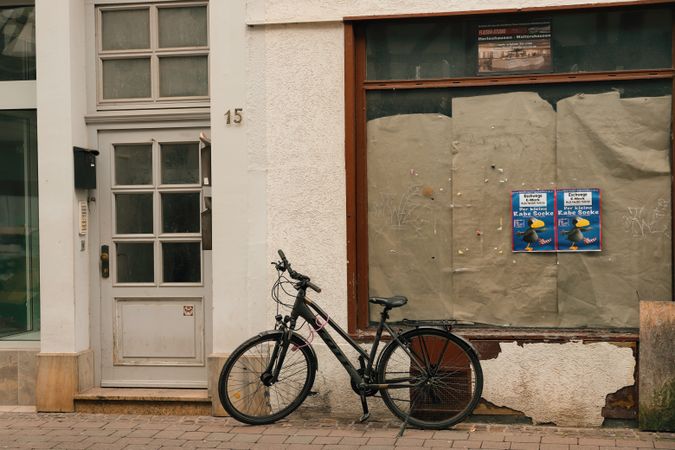 A bicycle is parked by a weathered door in the pedestrian precinct of Eschwege, Germany.